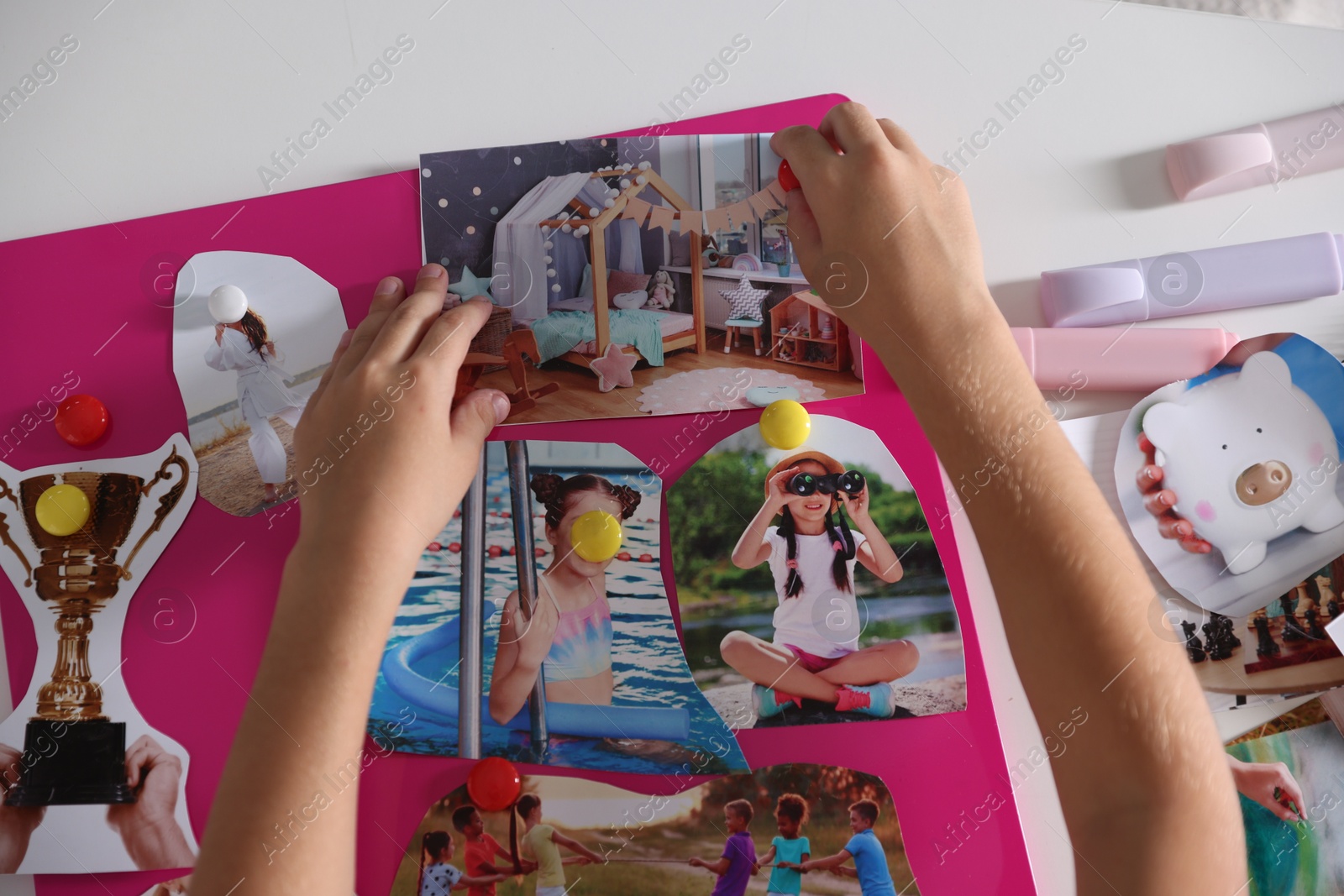 Photo of Girl creating vision board with different pictures at light table, top view