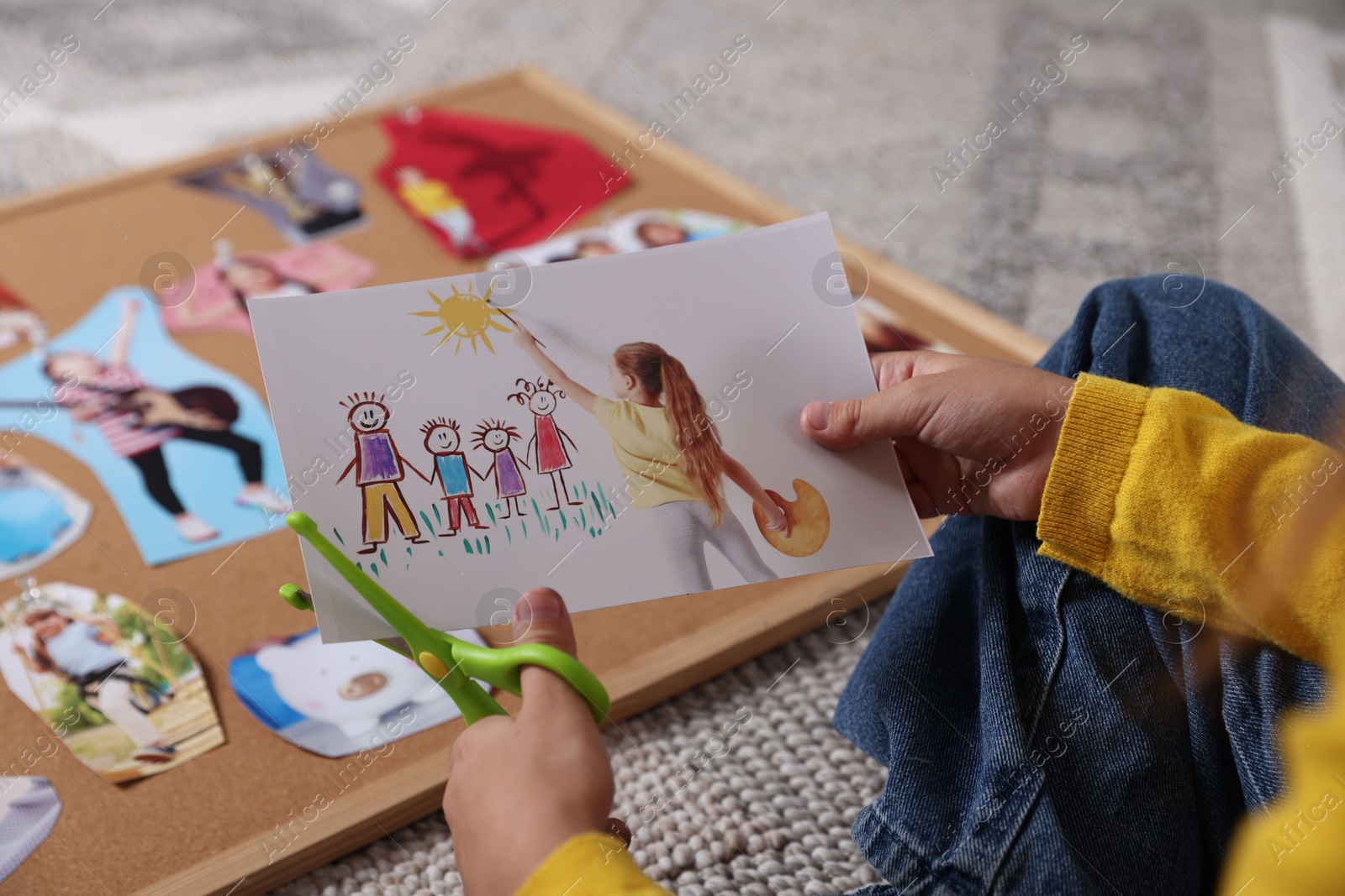 Photo of Creating vision board. Girl cutting out picture on floor, closeup