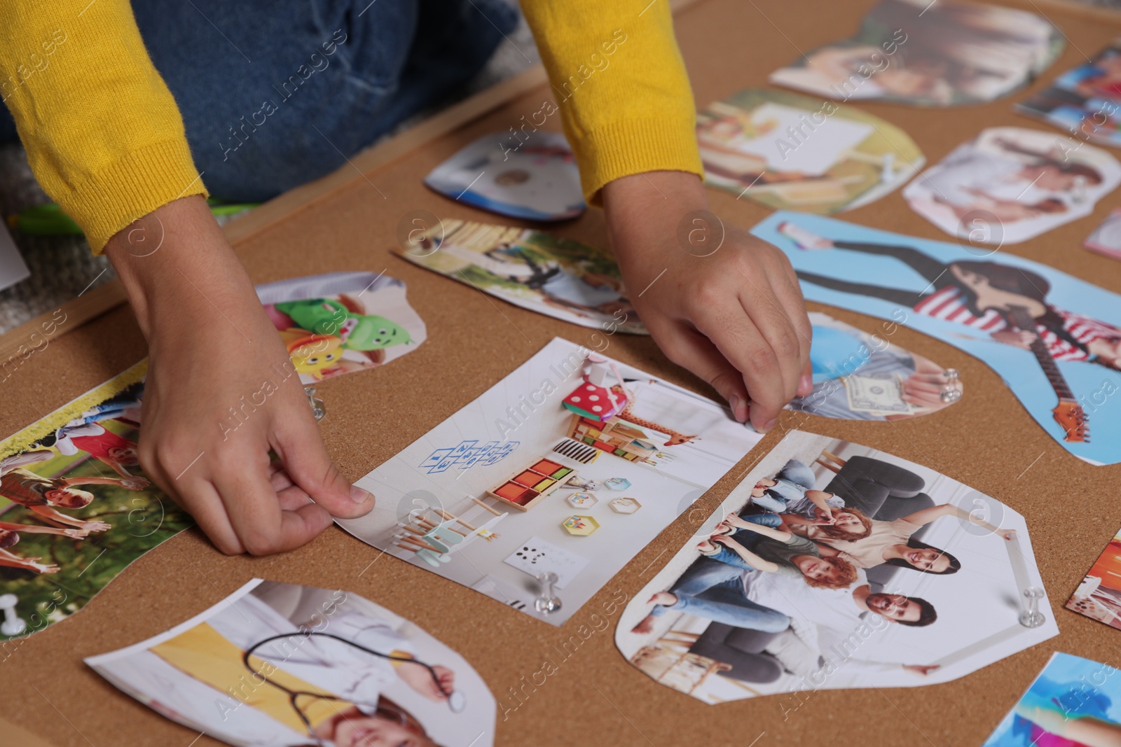 Photo of Girl creating vision board with different pictures, closeup