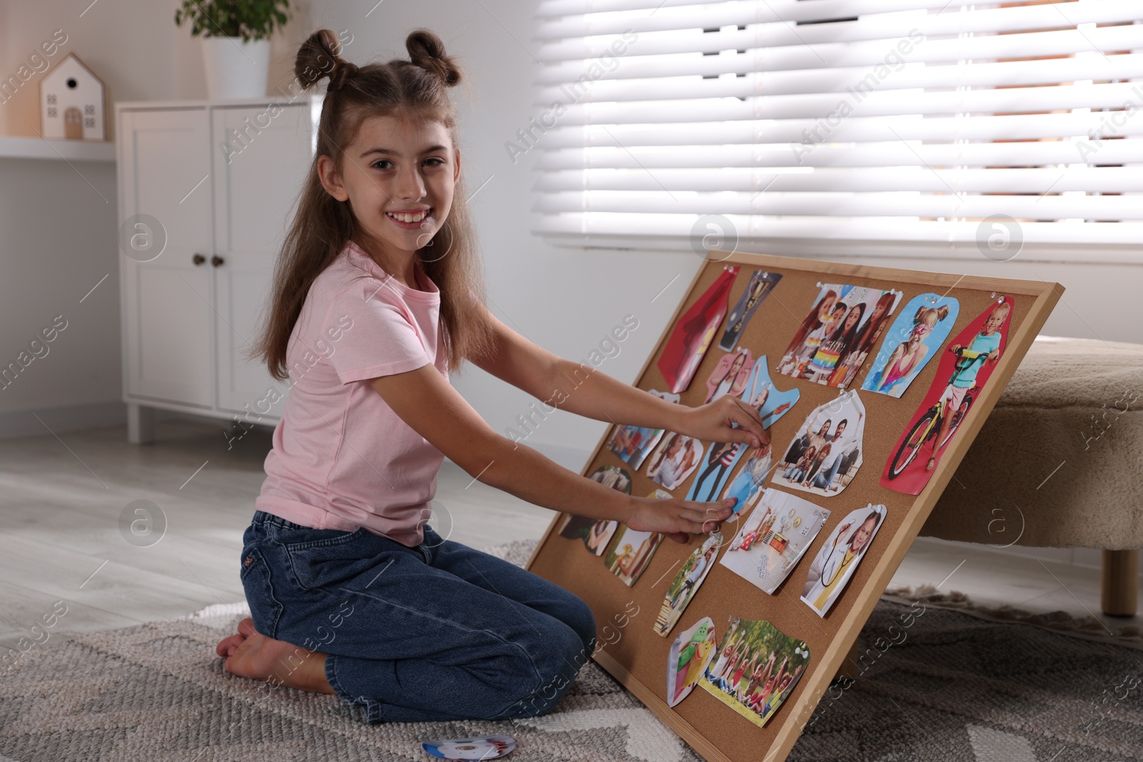 Photo of Girl creating vision board with different pictures on floor indoors