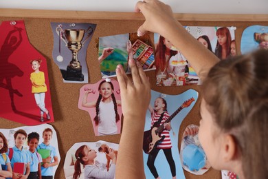 Girl creating vision board with different pictures indoors