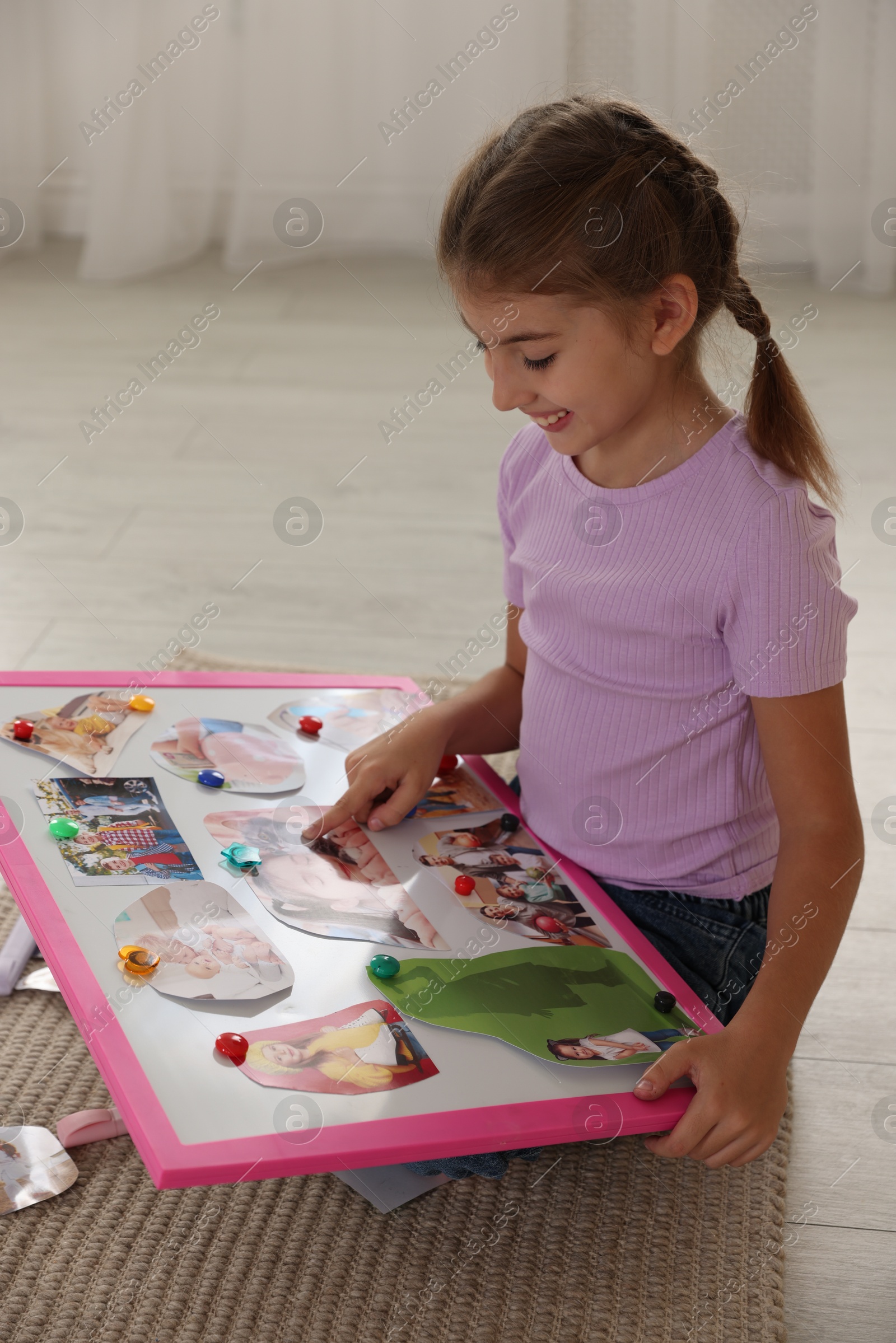 Photo of Girl with vision board on floor indoors