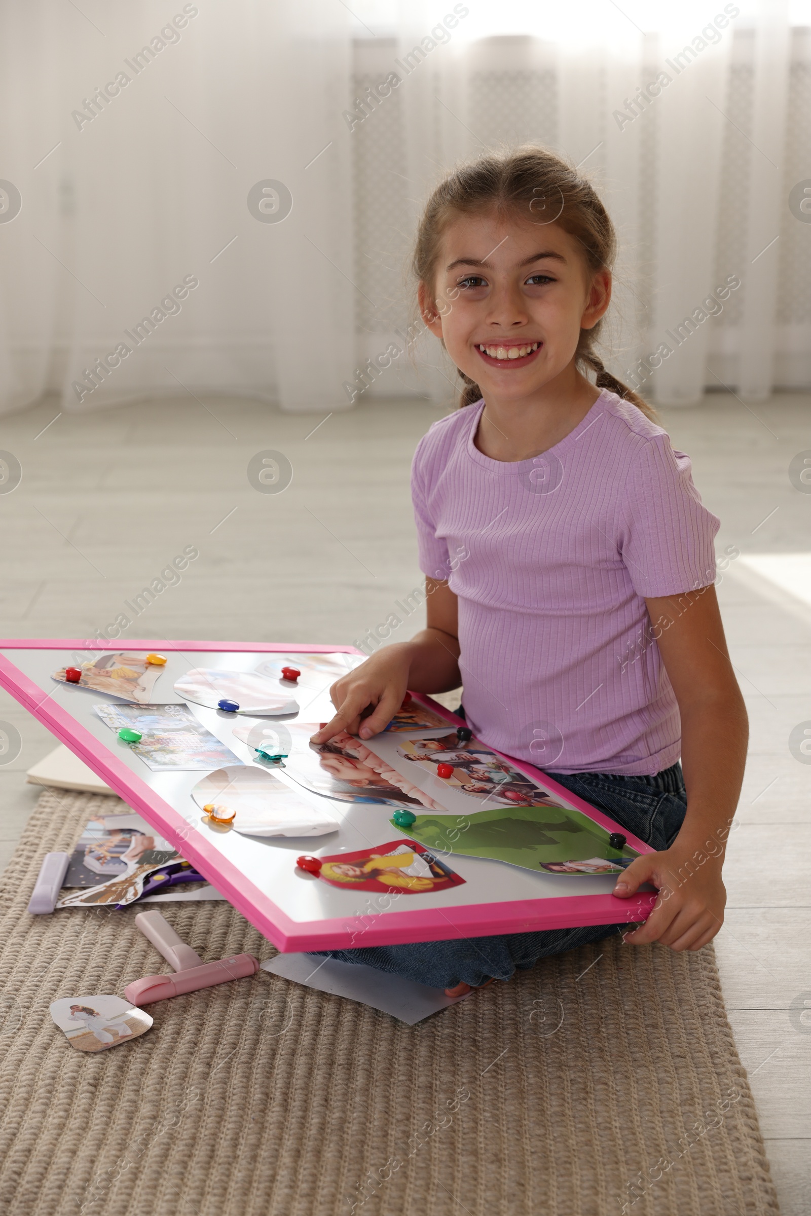 Photo of Girl with vision board on floor indoors