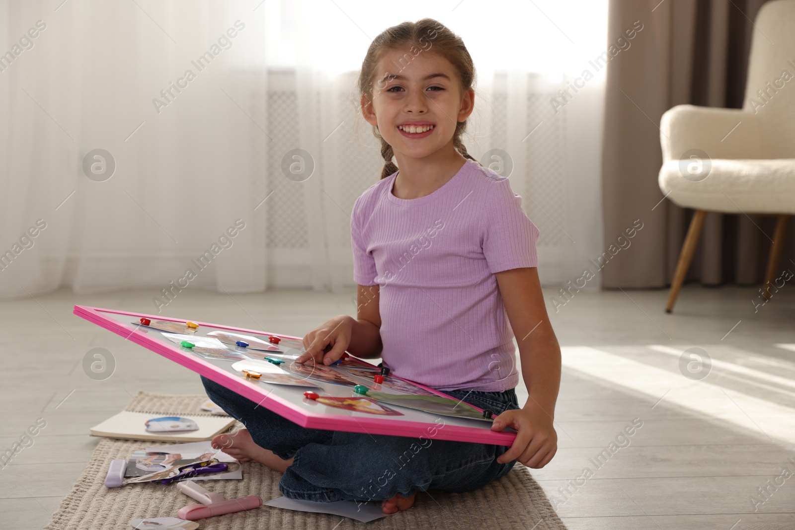 Photo of Girl with vision board on floor indoors