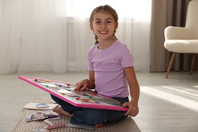 Girl with vision board on floor indoors