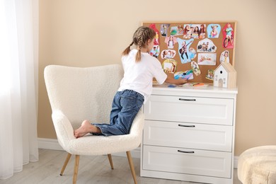 Girl creating vision board with different pictures at home