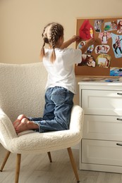 Girl creating vision board with different pictures at home