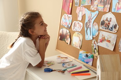 Girl creating looking at vision board with different pictures indoors