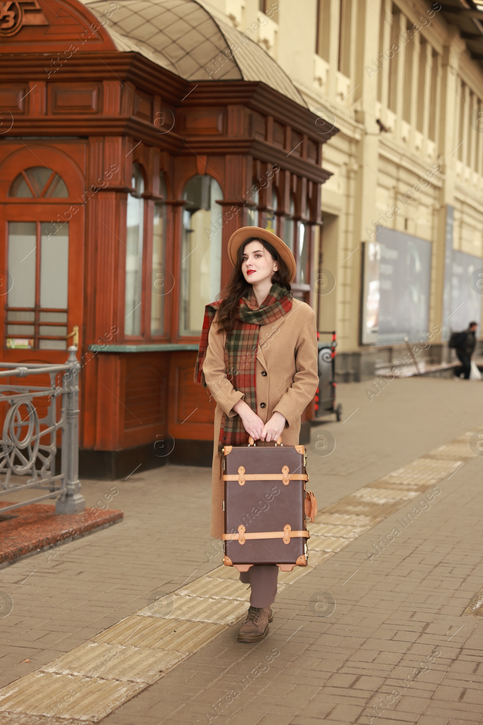 Photo of Beautiful woman with suitcase at railway station