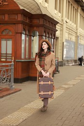 Beautiful woman with suitcase at railway station