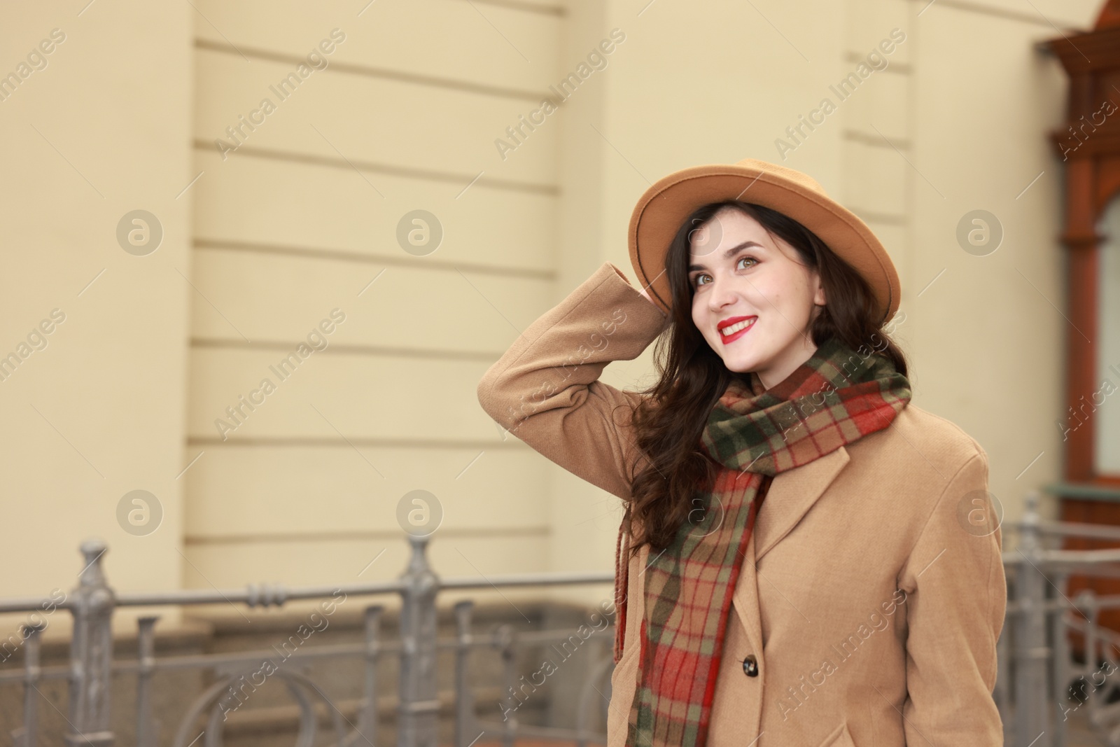 Photo of Beautiful woman in hat at railway station, space for text