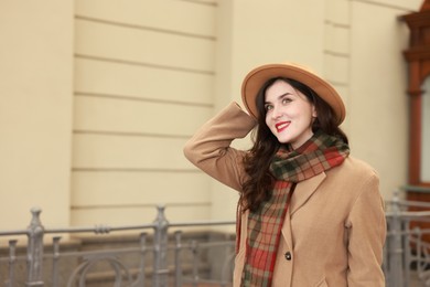 Beautiful woman in hat at railway station, space for text