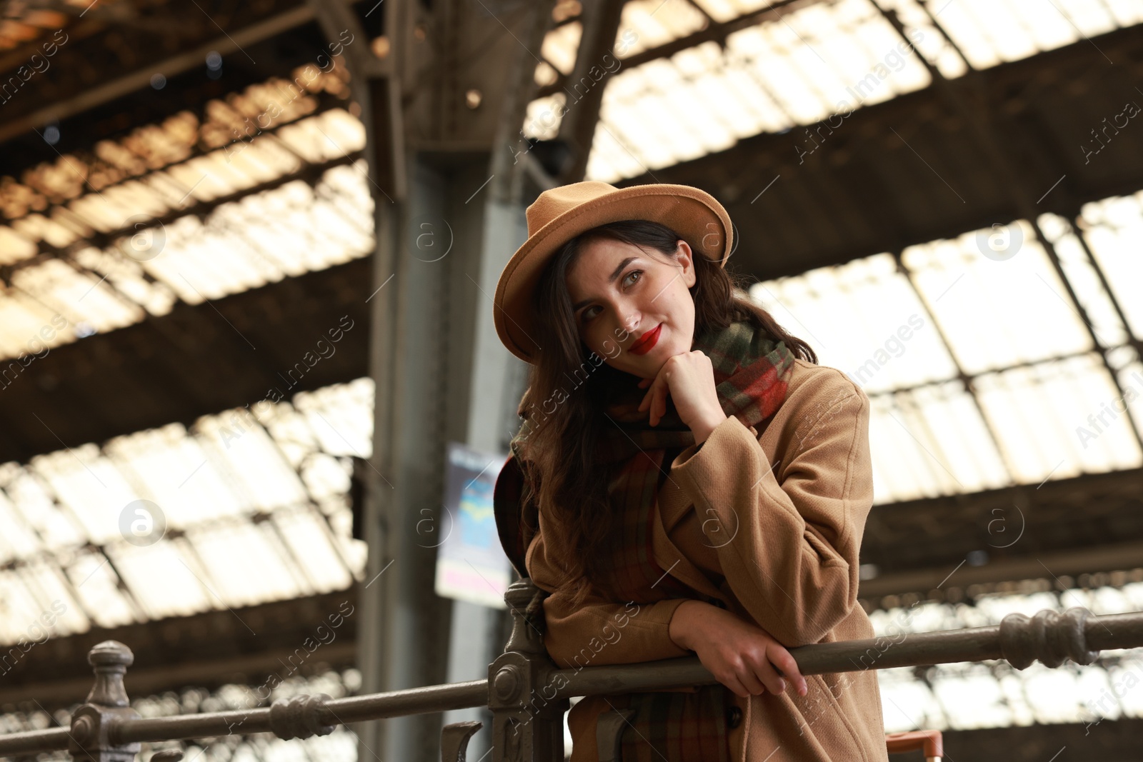 Photo of Beautiful woman in hat at railway station, space for text