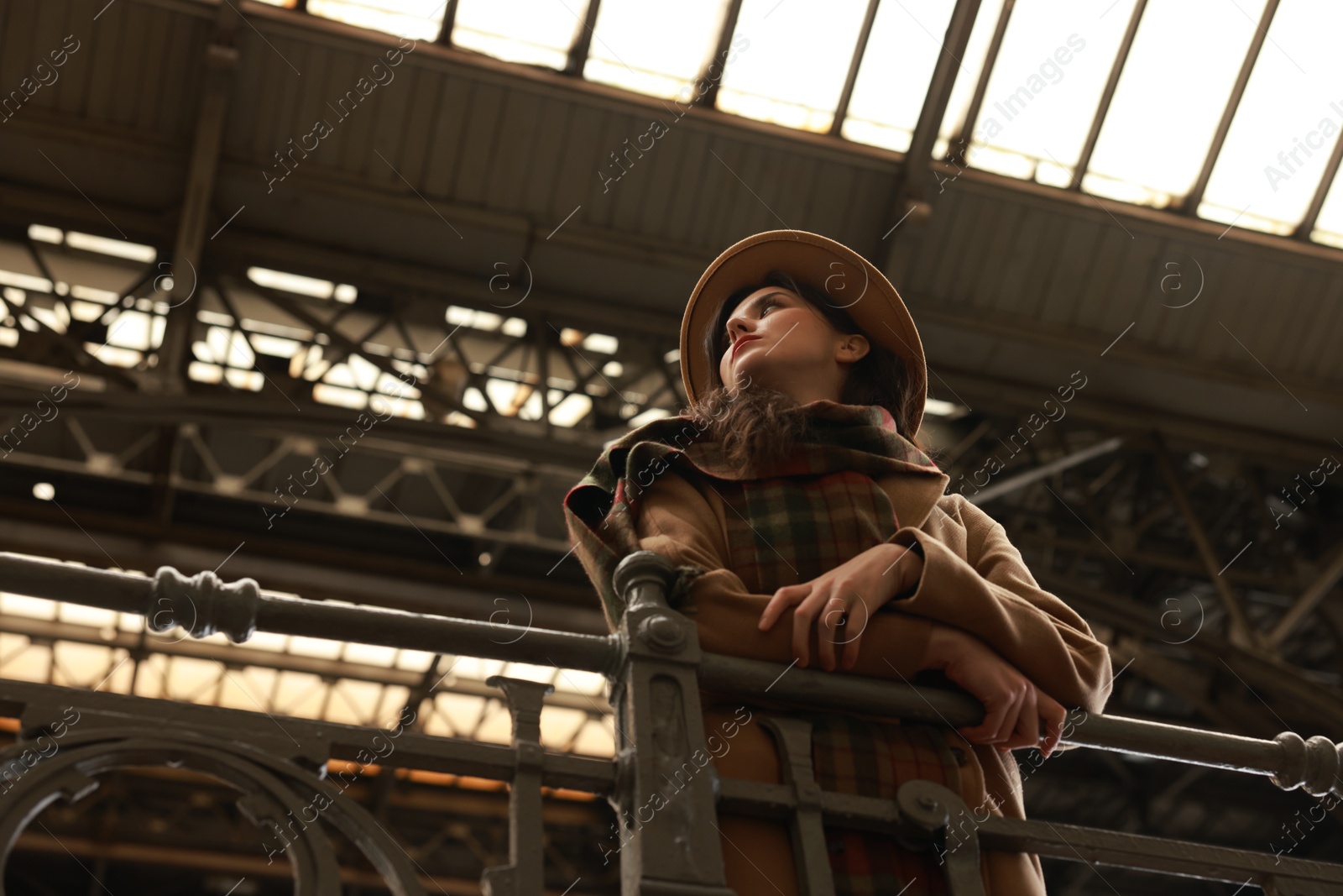 Photo of Beautiful woman in hat at railway station, low angle view