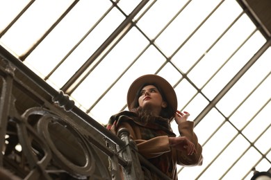 Photo of Beautiful woman in hat at railway station, low angle view