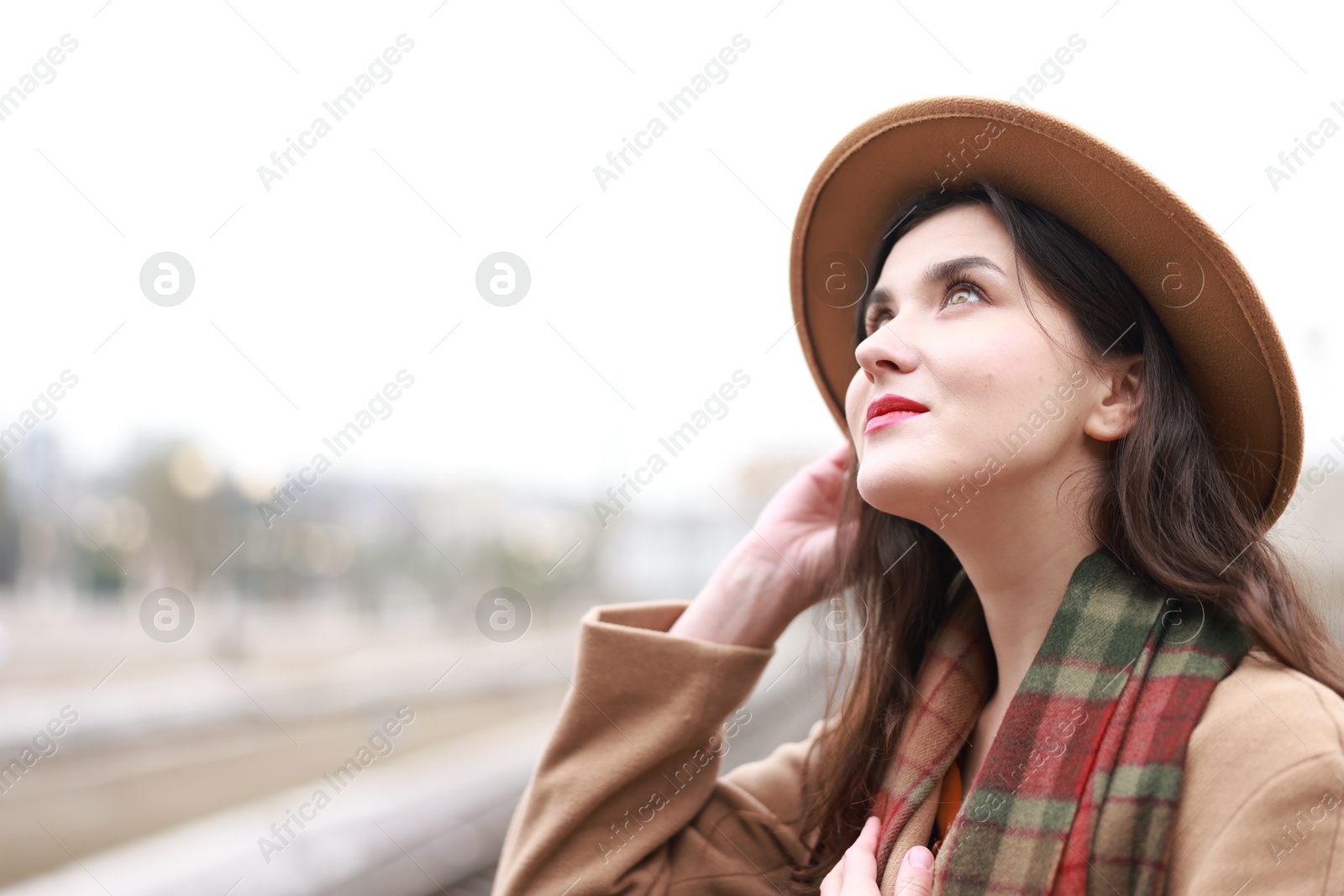 Photo of Beautiful woman in hat at railway station, space for text