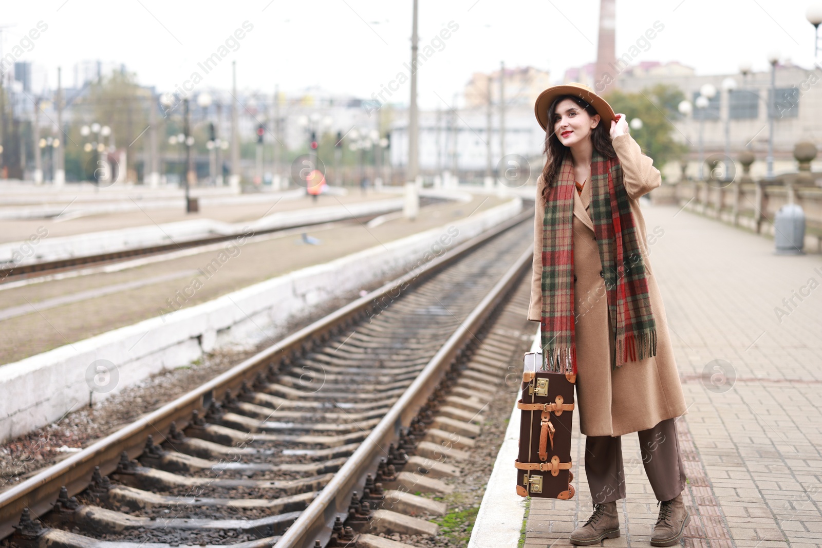 Photo of Beautiful woman with suitcase at railway station