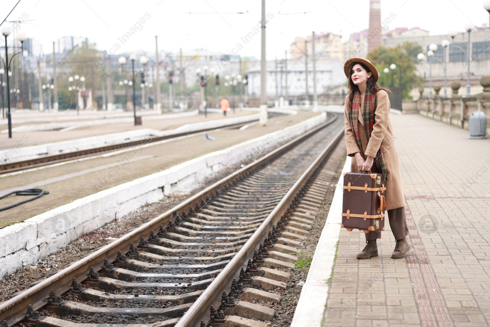 Photo of Beautiful woman with suitcase at railway station