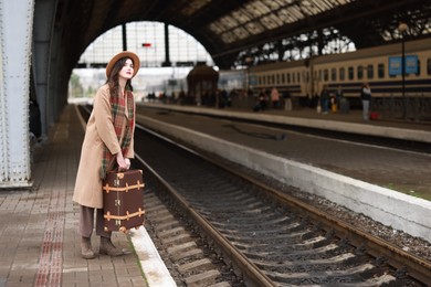 Photo of Beautiful woman with suitcase at railway station