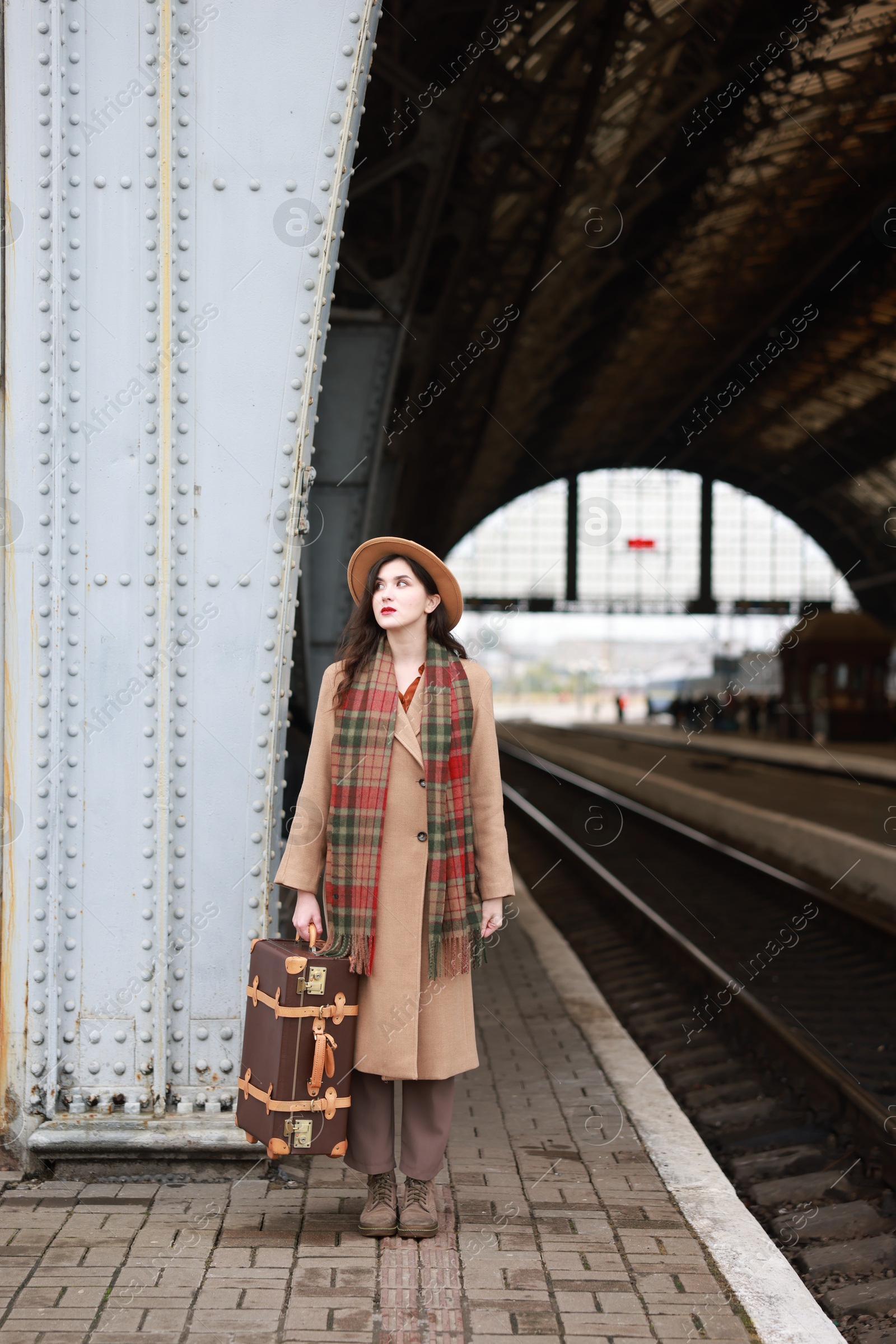 Photo of Beautiful woman with suitcase at railway station