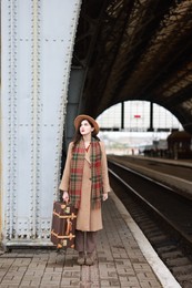 Beautiful woman with suitcase at railway station