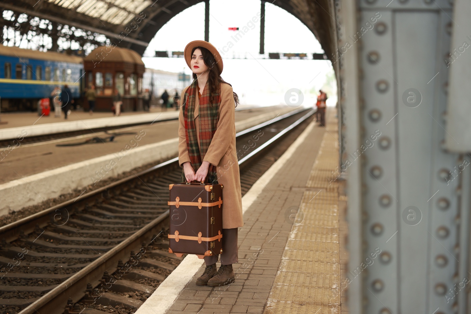 Photo of Beautiful woman with suitcase at railway station