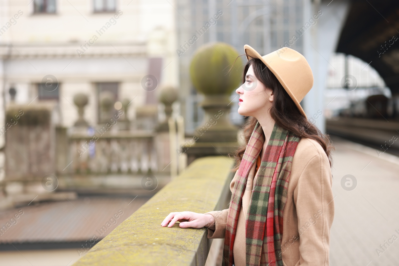 Photo of Beautiful woman on platform of railway station, space for text