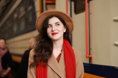 Photo of Woman with red scarf near train on platform of railway station