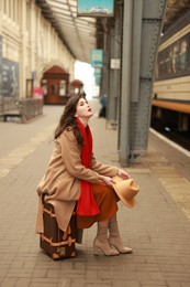 Photo of Woman with suitcase on platform of railway station