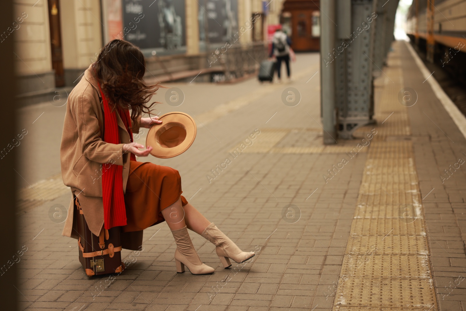 Photo of Woman with suitcase on platform of railway station