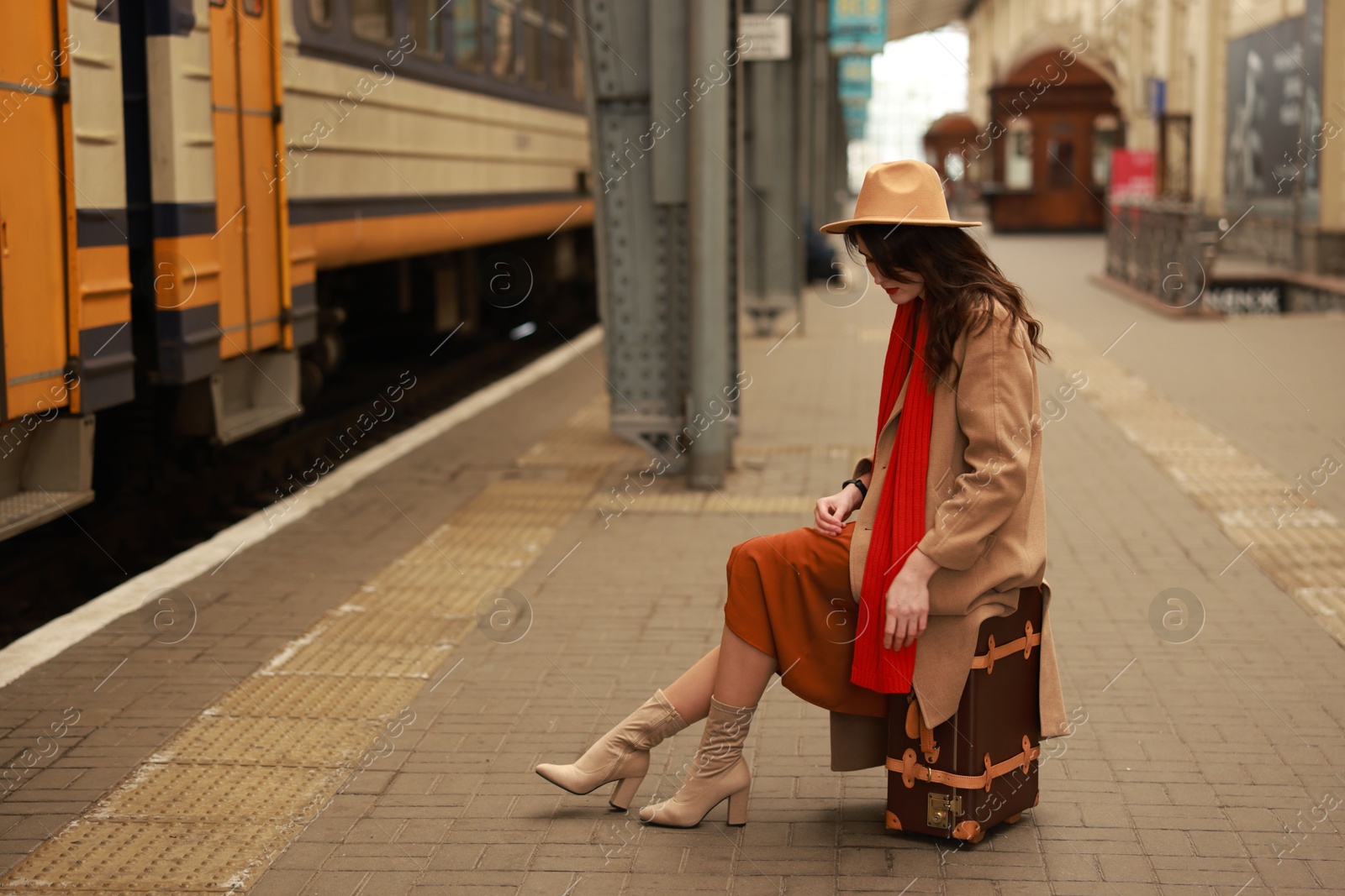 Photo of Woman with suitcase on platform of railway station