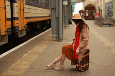 Photo of Woman with suitcase on platform of railway station