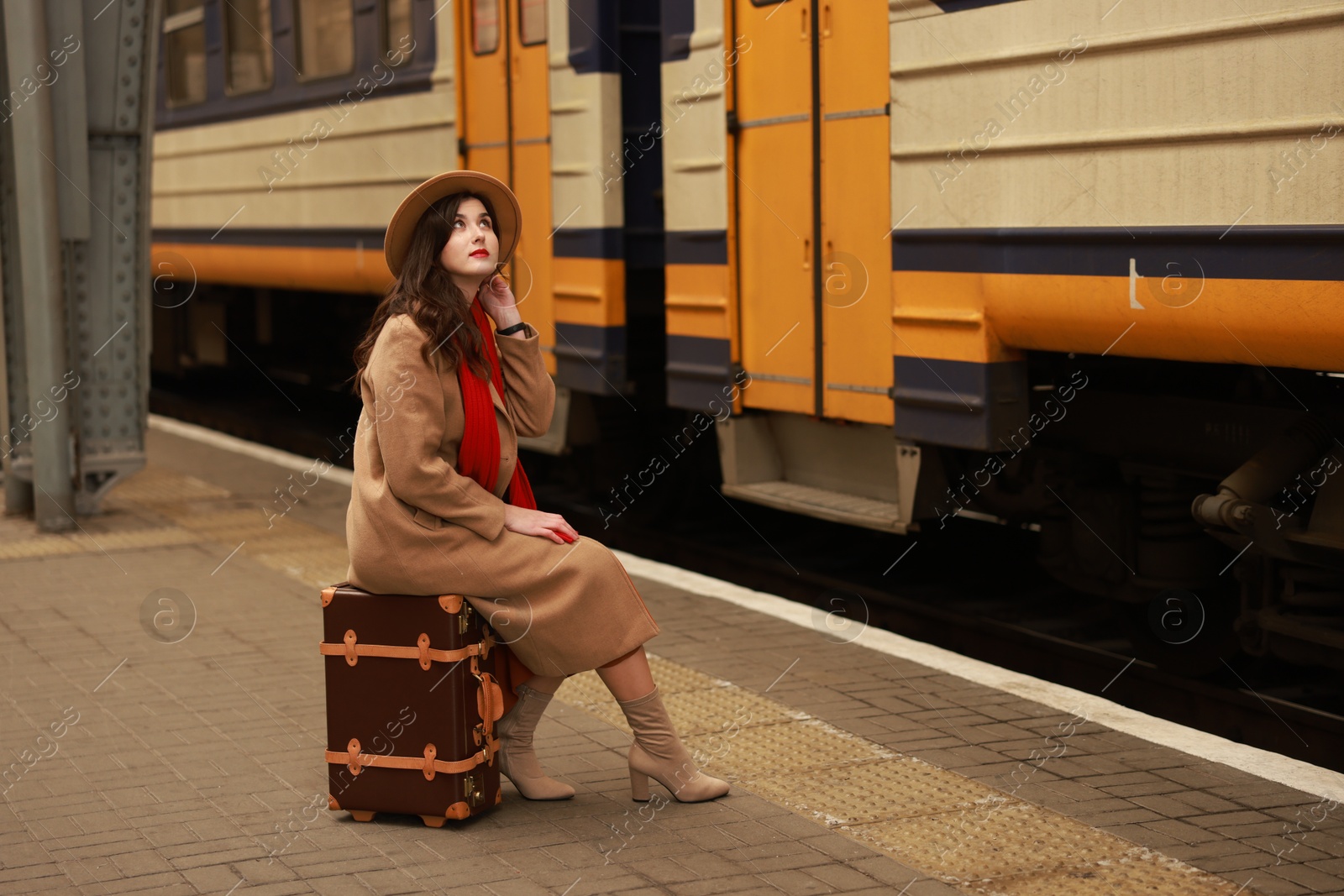 Photo of Woman with suitcase on platform of railway station