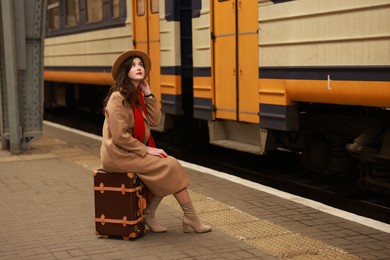 Photo of Woman with suitcase on platform of railway station