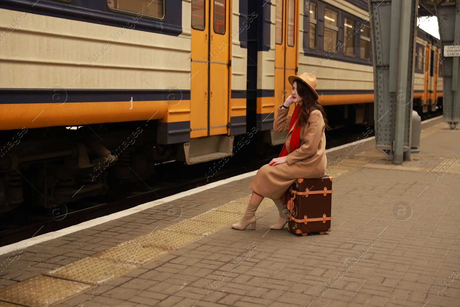 Photo of Woman with suitcase on platform of railway station