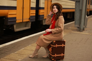 Woman with suitcase on platform of railway station