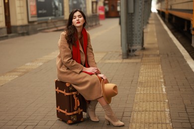 Photo of Woman with suitcase on platform of railway station