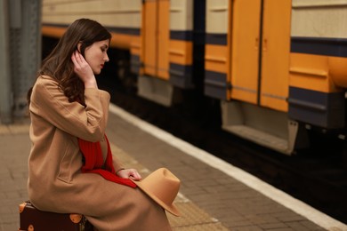 Photo of Woman with suitcase on platform of railway station