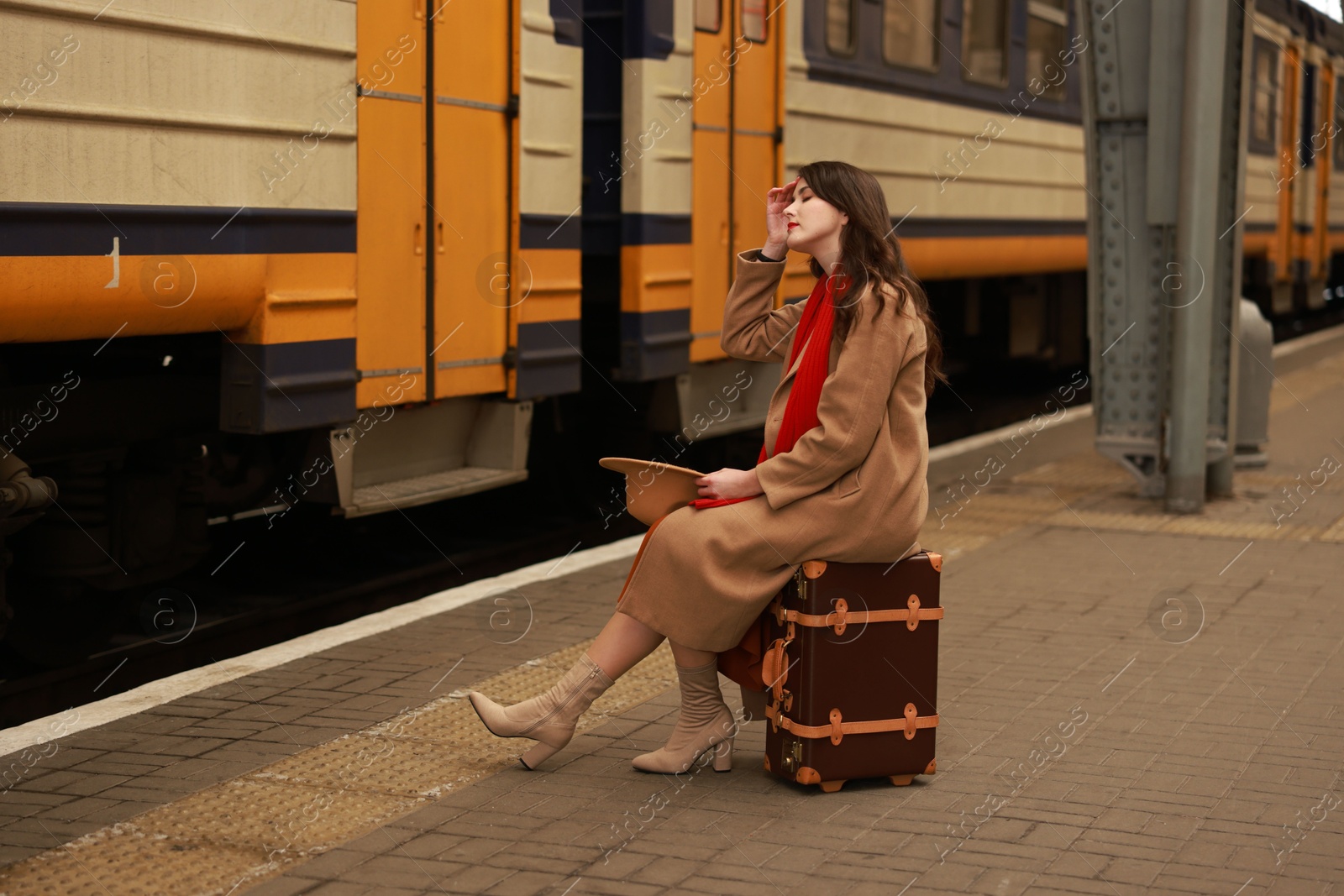 Photo of Woman with suitcase on platform of railway station