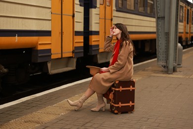 Photo of Woman with suitcase on platform of railway station