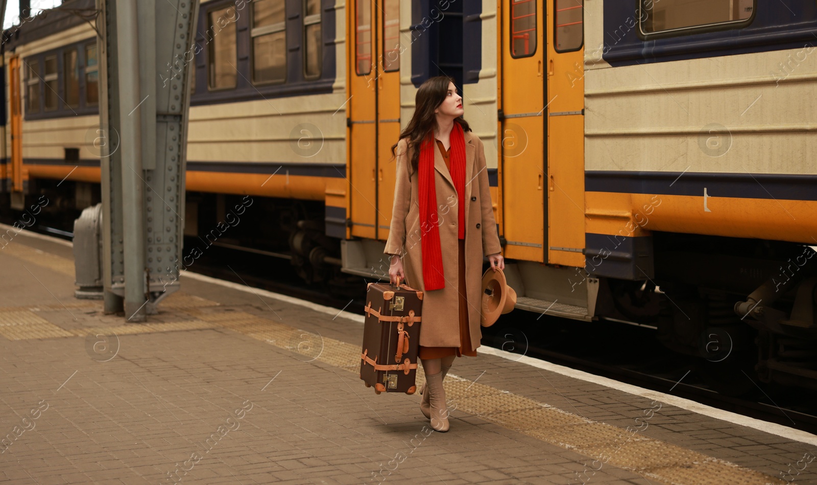 Photo of Woman with suitcase on platform of railway station