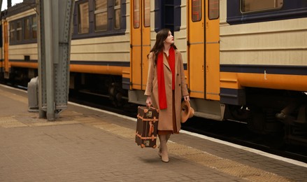 Woman with suitcase on platform of railway station