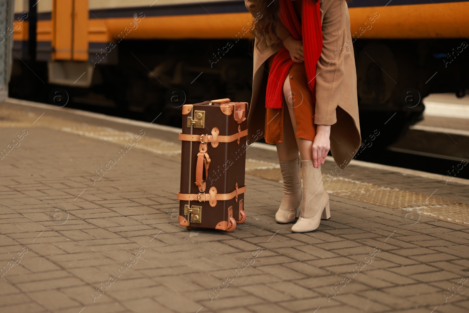 Photo of Woman with suitcase on platform of railway station, closeup