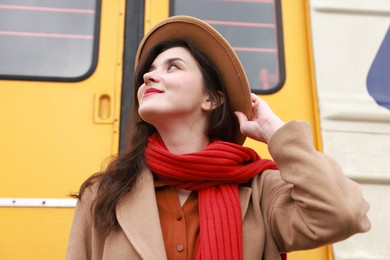 Photo of Beautiful woman with red scarf near train outdoors, low angle view