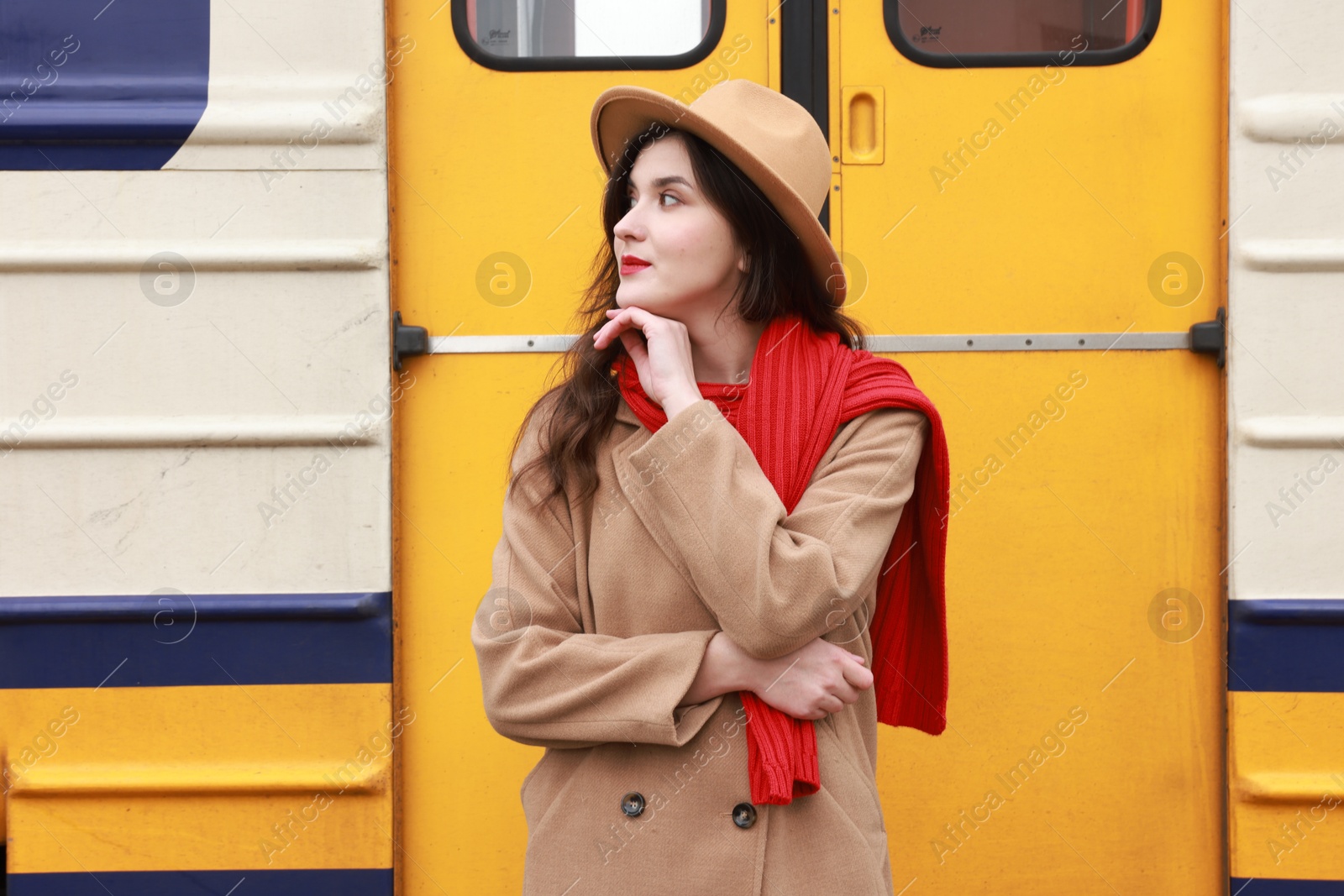 Photo of Beautiful woman with red scarf near train outdoors