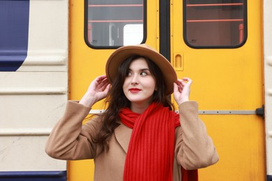 Photo of Beautiful woman with red scarf near train outdoors