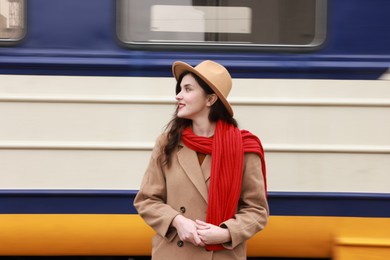 Photo of Beautiful woman with red scarf near train outdoors