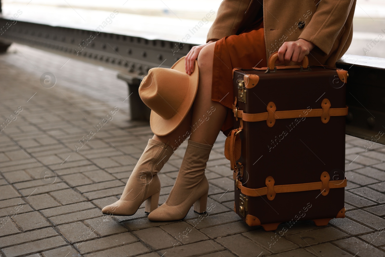 Photo of Woman with suitcase on platform of railway station, closeup. Space for text