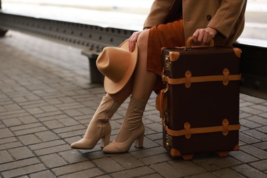 Photo of Woman with suitcase on platform of railway station, closeup. Space for text