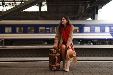 Woman with suitcase on platform of railway station